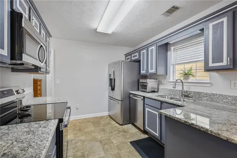 a kitchen with stainless steel appliances granite countertop a sink stove and refrigerator