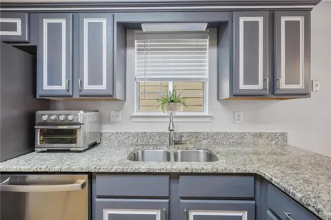 a kitchen with granite countertop stainless steel appliances window sink and cabinets