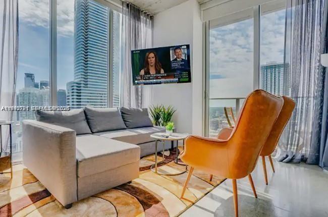 151 Southeast 1st Street, Unit 3111 Miami, FL 33131 - Photo 1 of 35 a living room with furniture a flat screen tv and a window