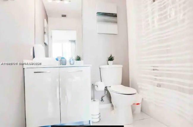 151 Southeast 1st Street, Unit 3111 Miami, FL 33131 - Photo 11 of 35 a white toilet sitting next to a bathroom sink