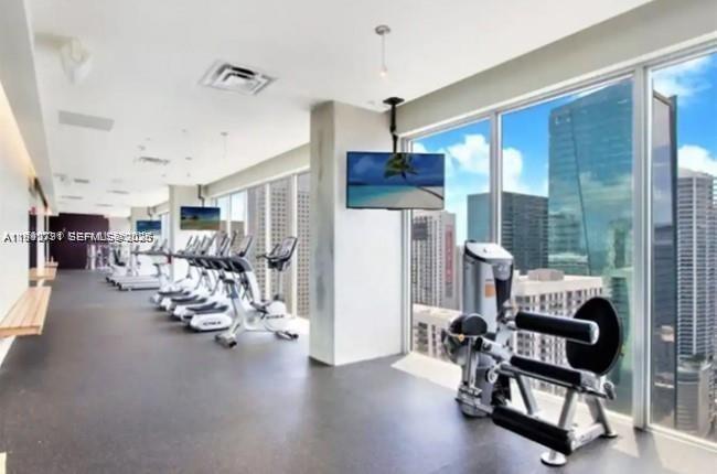 151 Southeast 1st Street, Unit 3111 Miami, FL 33131 - Photo 22 of 35 a view of a livingroom with furniture and a gym