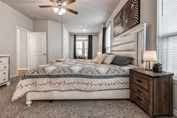 a bedroom with a bed and dresser with mirror