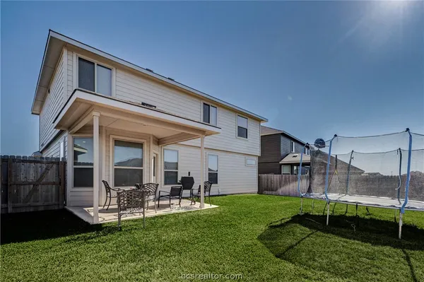 a view of a chair and table in backyard of the house