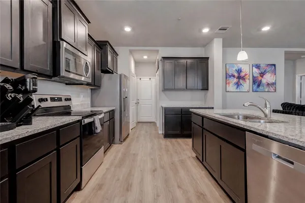 a kitchen with stainless steel appliances granite countertop a sink a stove and a refrigerator