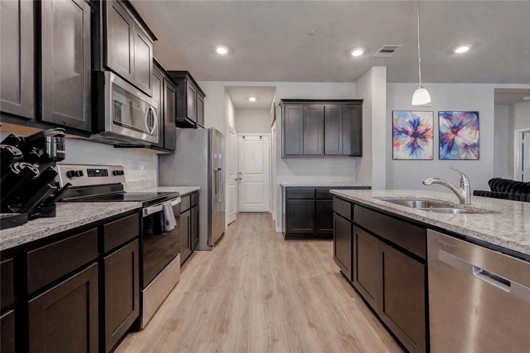 2176 Chief Street Bryan, TX 77807 - Photo 8 of 21 a kitchen with stainless steel appliances granite countertop a sink a stove and a refrigerator