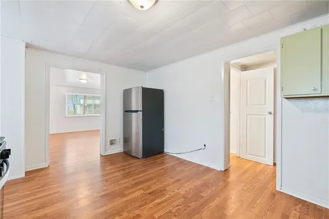 a view of empty room with wooden floor and window