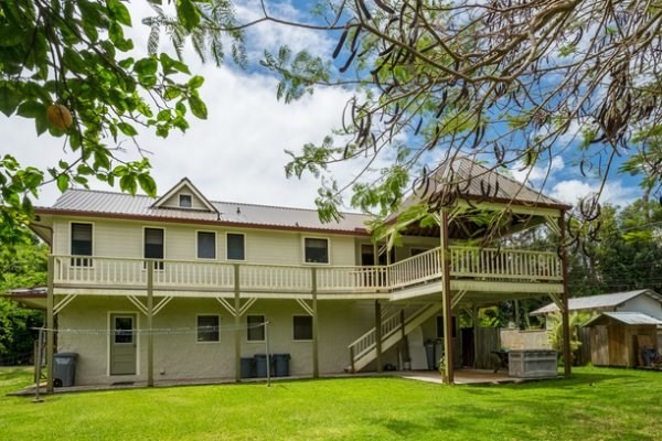 6280 Kalama Road Kapaa, HI 96746 - Photo 24 of 25 a view of a white house with a big yard and potted plants and large trees