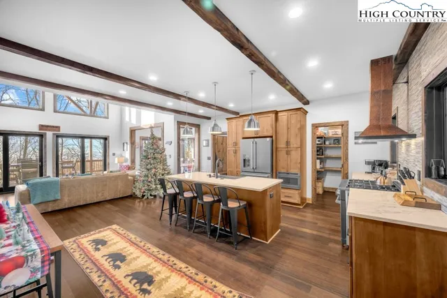 a kitchen with stainless steel appliances a stove sink refrigerator dining table and chairs