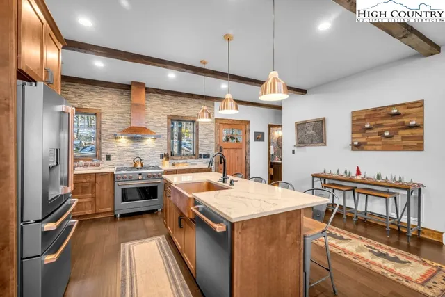 a kitchen with stainless steel appliances granite countertop a sink stove and refrigerator