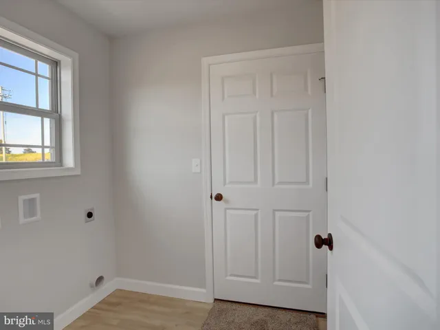 an empty room with windows and cabinet
