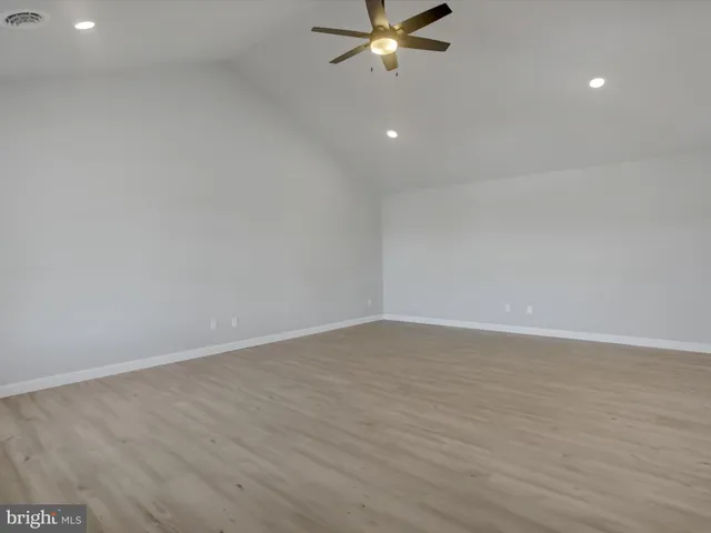 an empty room with a wooden floor and windows