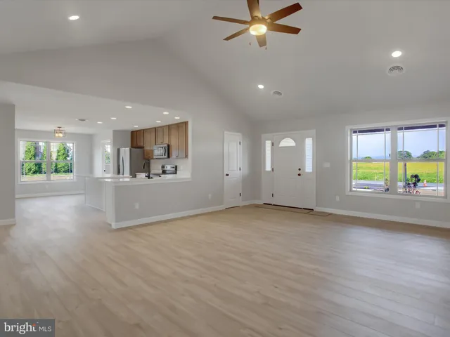 an empty room with windows and ceiling fan