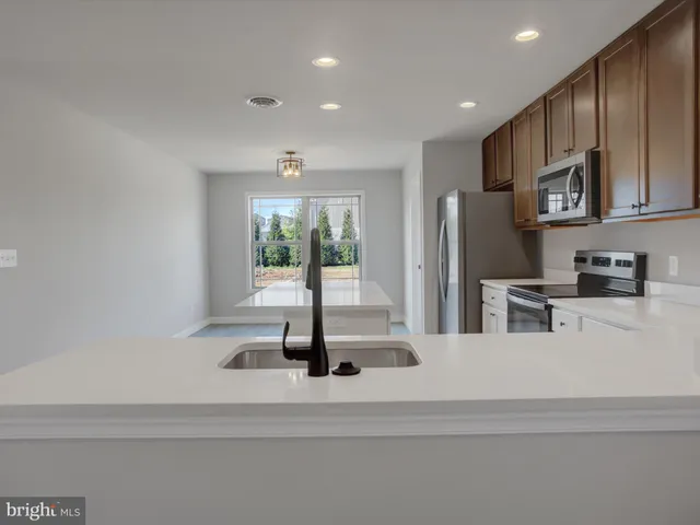 a kitchen with cabinets stainless steel appliances and a counter space