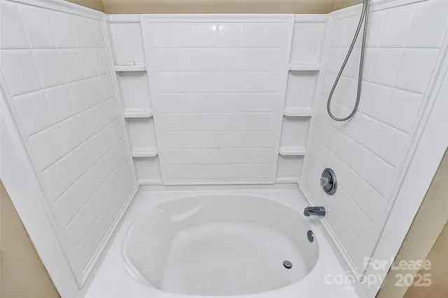 a bathroom with a white bath tub and a shower