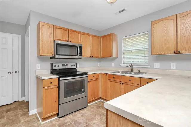 a kitchen with stainless steel appliances granite countertop a stove a sink and a microwave