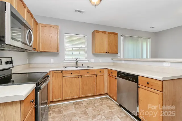 a kitchen that has a sink and a stove in it