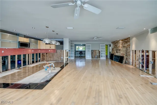 a view of a living room with wooden floor and a fireplace