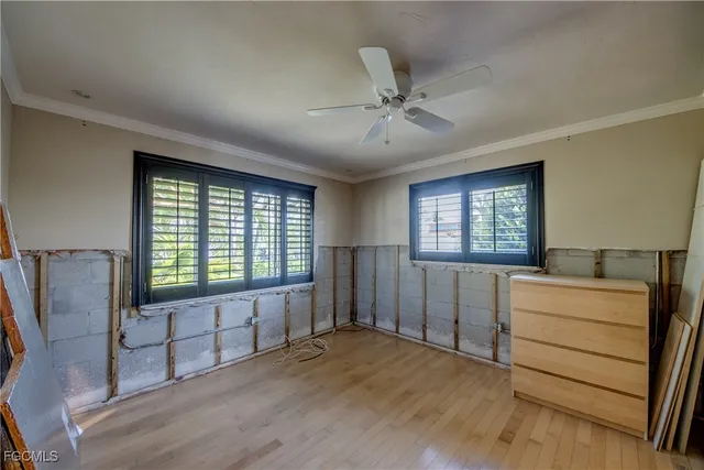 a view of a kitchen with furniture a ceiling fan and wooden floor