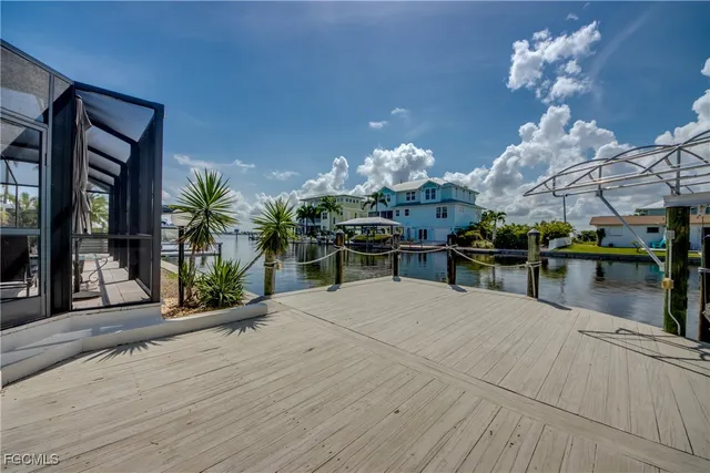 a view of a patio with table and chairs with wooden floor and fence