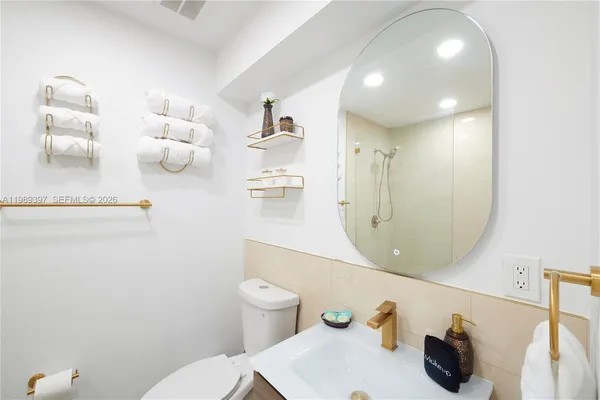 a bathroom with a sink a toilet and mirror