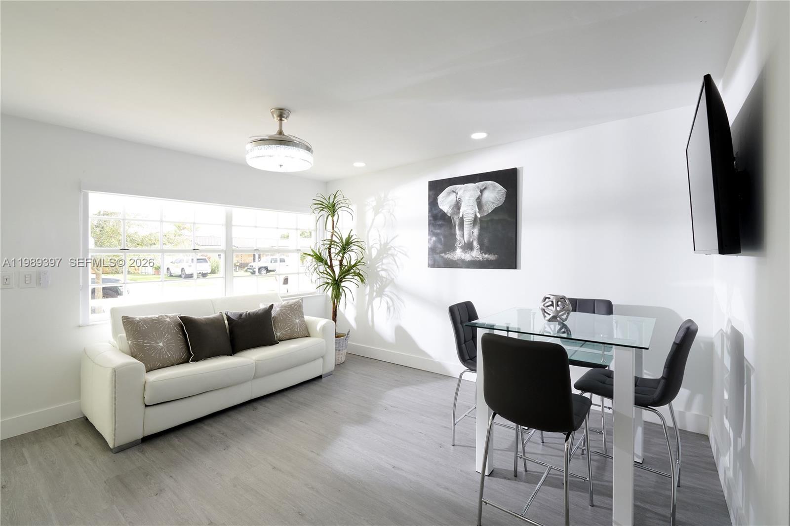 12293 Southwest 28th Terrace Miami, FL 33175 - Photo 21 of 25 a living room with furniture a large window and a flat screen tv