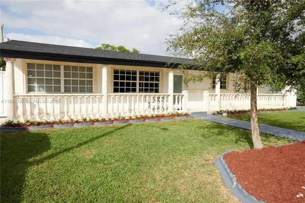 a front view of a house with a yard and fence