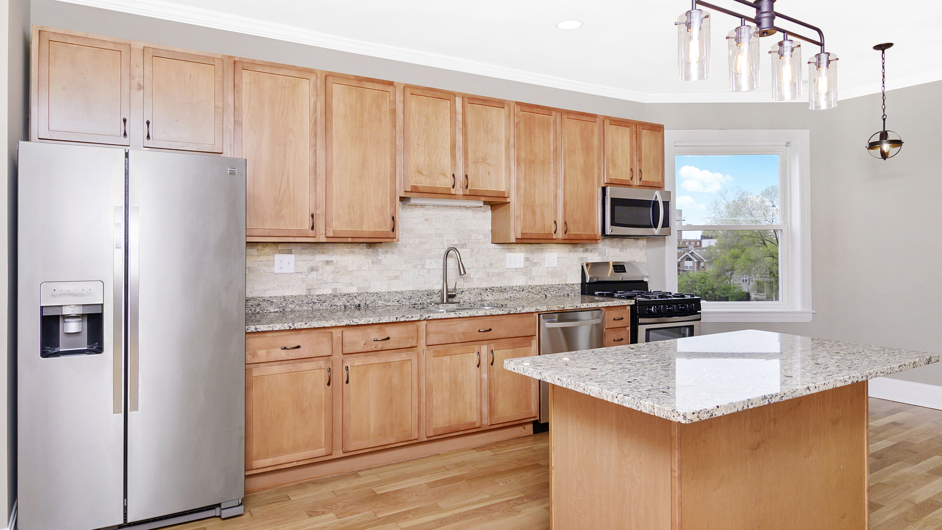 4918 South St Lawrence Avenue, Unit 3 Chicago, IL 60615 - Photo 7 of 16 a kitchen with kitchen island granite countertop a stove top oven a sink dishwasher and a refrigerator with wooden floor