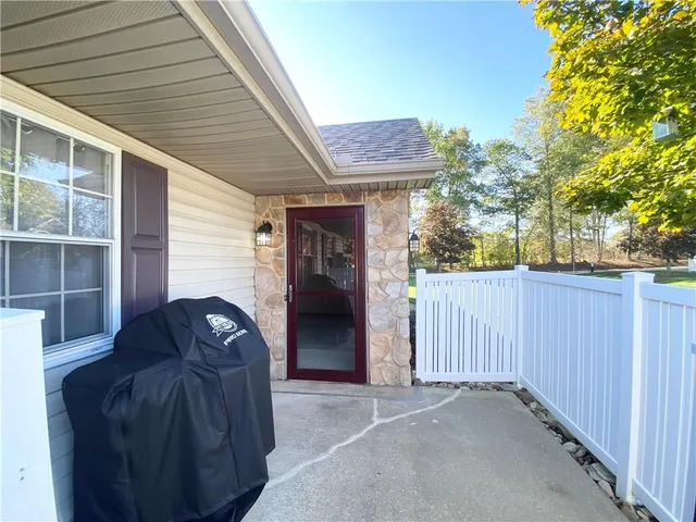 a view of a house with a large window and wooden fence