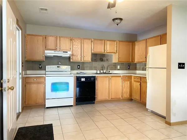 a kitchen with a white stove top oven sink and cabinets