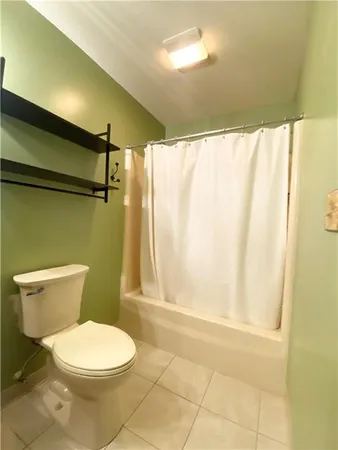 a white toilet sitting next to a shower curtain