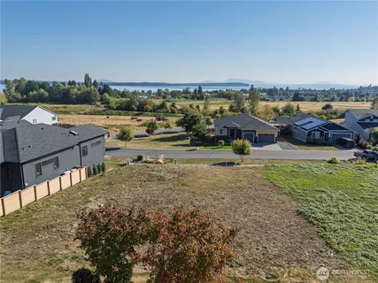 an aerial view of a house with a yard and lake view