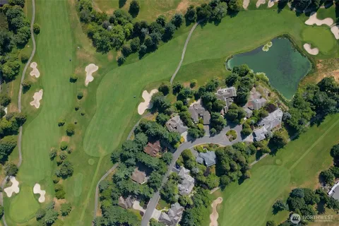 an aerial view of a residential houses with outdoor space and trees