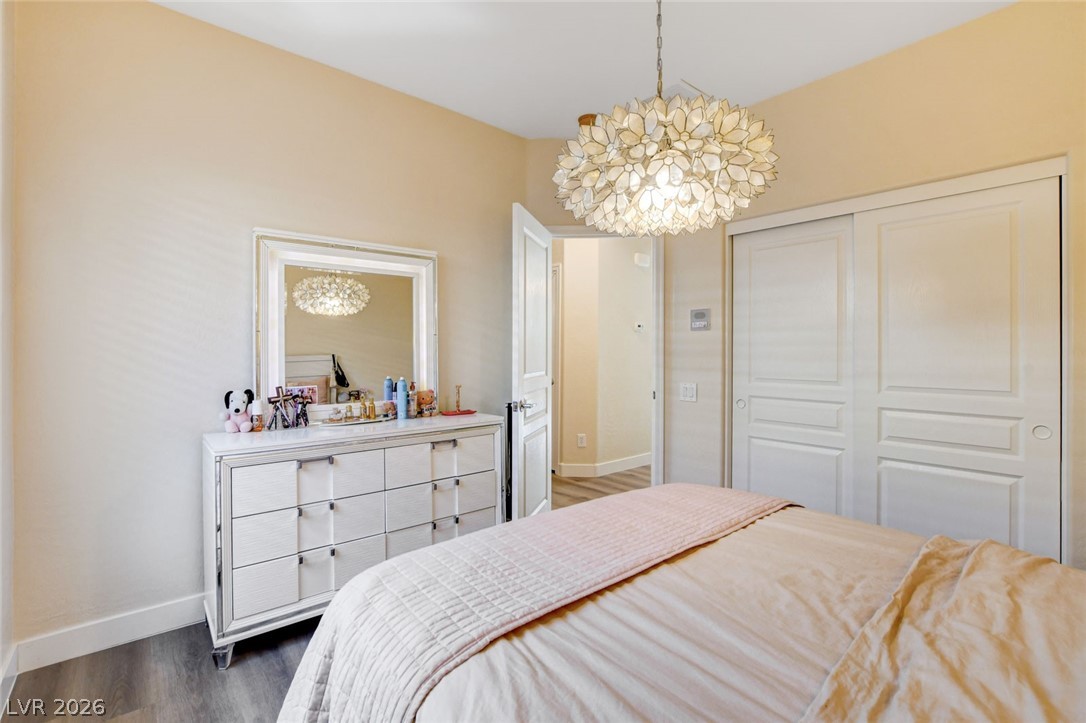 2649 Rue Marquette Avenue Henderson, NV 89044 - Photo 32 of 55 This serene sleeping space features smooth laminate flooring and a distinctive ceiling fixture, ideal for restful nights.