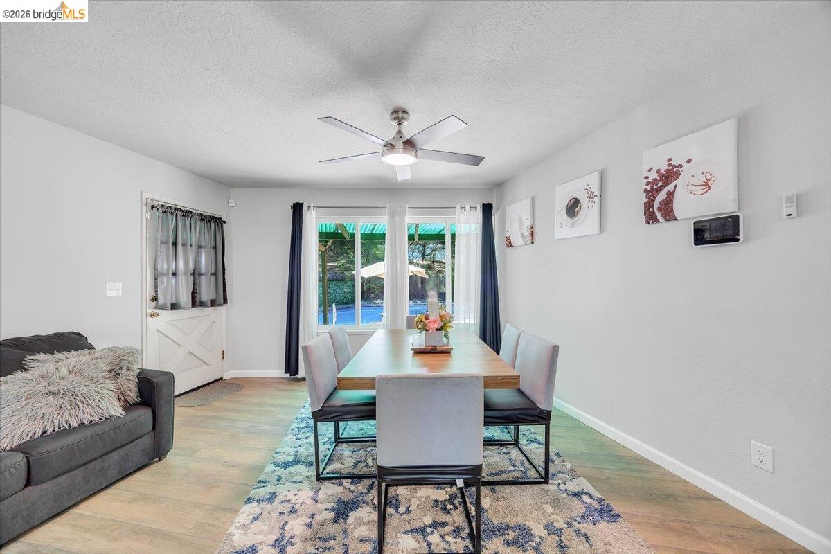8733 Fraguero Road Sonora, CA 95370 - Photo 35 of 73 Dining area featuring light wood-finish flooring, a modern ceiling fan, and large windows with privacy blinds
