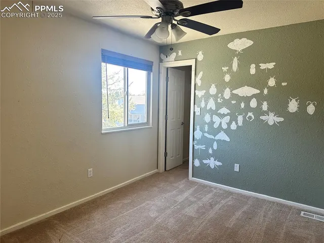 an empty room with windows and fan