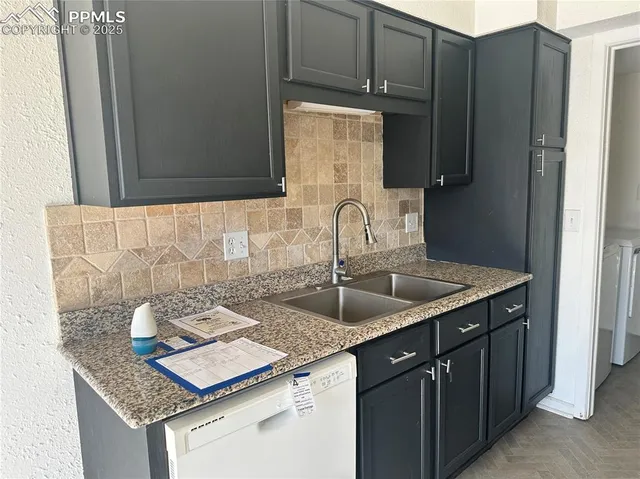 a kitchen with granite countertop a sink stove and cabinets