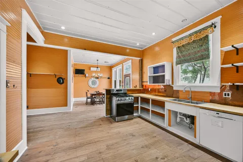 a dining room with wooden floor and chandelier