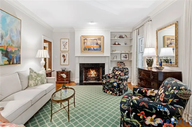 a living room with furniture fireplace and a large window
