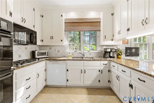 a kitchen with cabinets appliances a sink and a window
