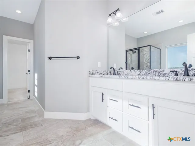 a bathroom with a sink a mirror and a shower