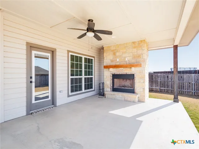 a view of an empty room with a fireplace and a window