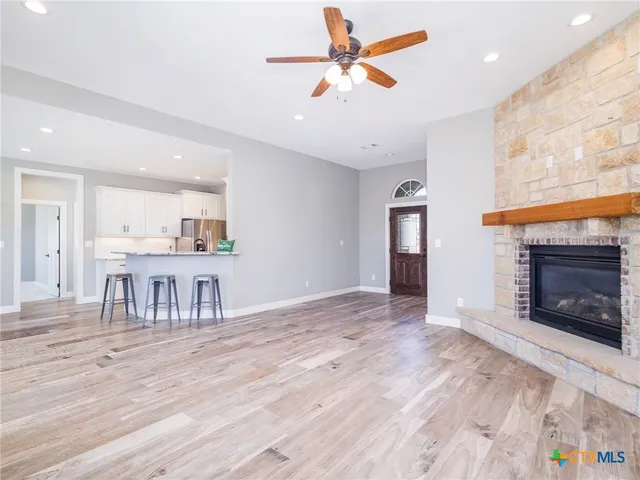 a view of an empty room with a fireplace and a window
