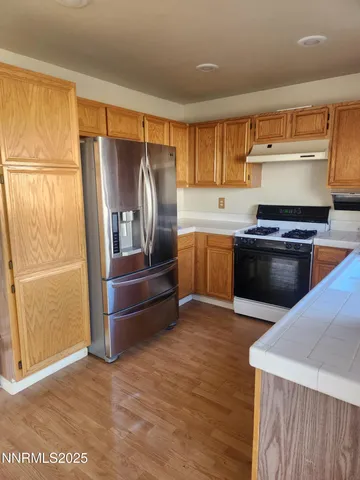 a kitchen with granite countertop a refrigerator and a stove