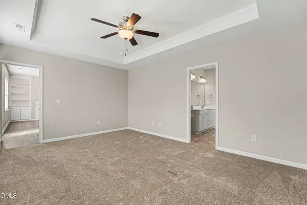 a view of an empty room and a ceiling fan