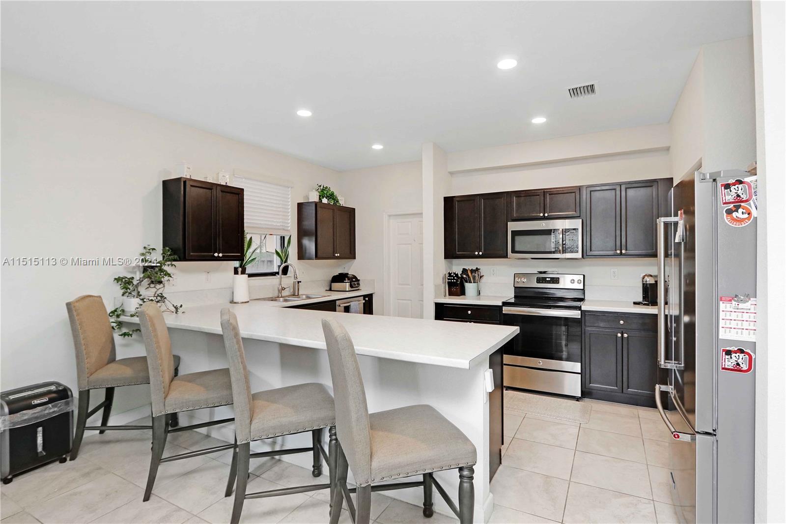 3448 Southeast 3rd Street Homestead, FL 33033 - Photo 8 of 27 a kitchen with a sink stainless steel appliances and chairs