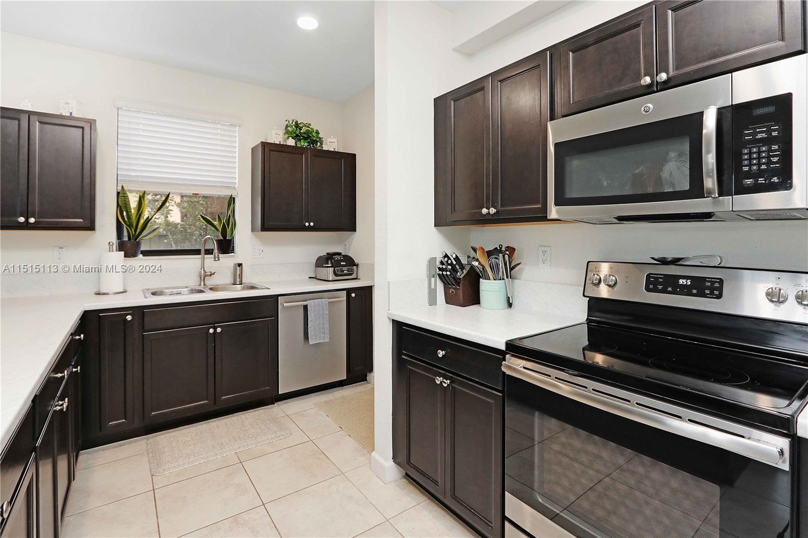 3448 Southeast 3rd Street Homestead, FL 33033 - Photo 9 of 27 a kitchen with stainless steel appliances a stove microwave and sink