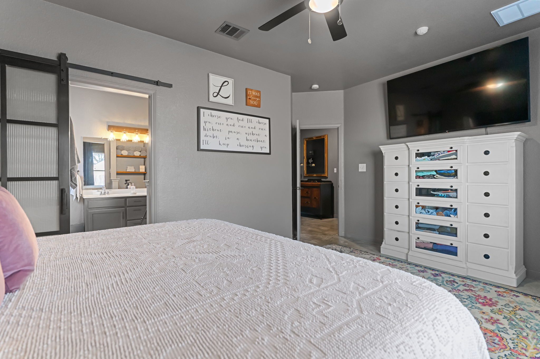 401 Kates Way Hutto, TX 78634 - Photo 15 of 37 Bedroom featuring a barn door, ensuite bathroom, and ceiling fan