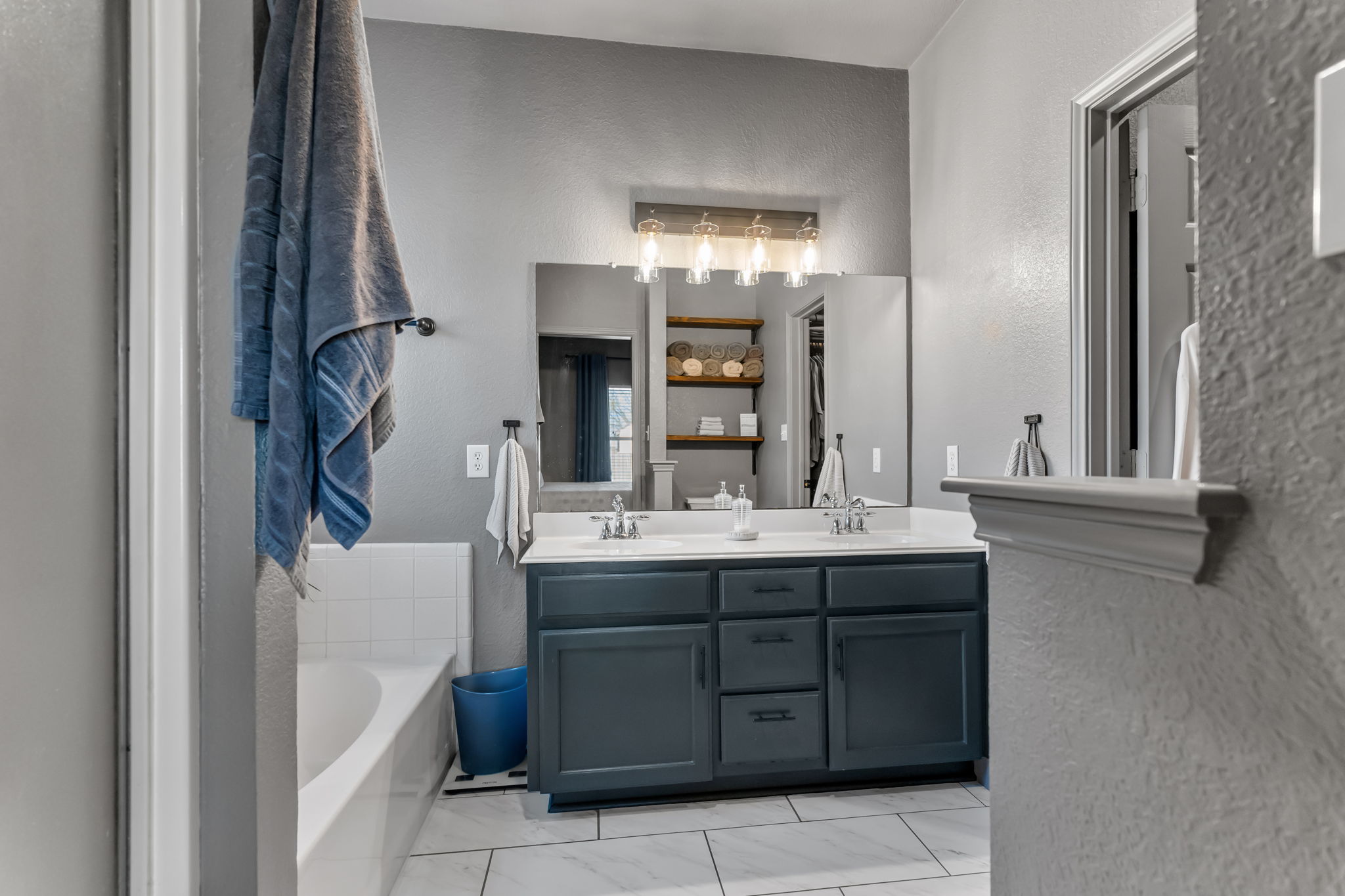 401 Kates Way Hutto, TX 78634 - Photo 17 of 37 Full bathroom featuring a textured wall, double vanity, and a garden tub
