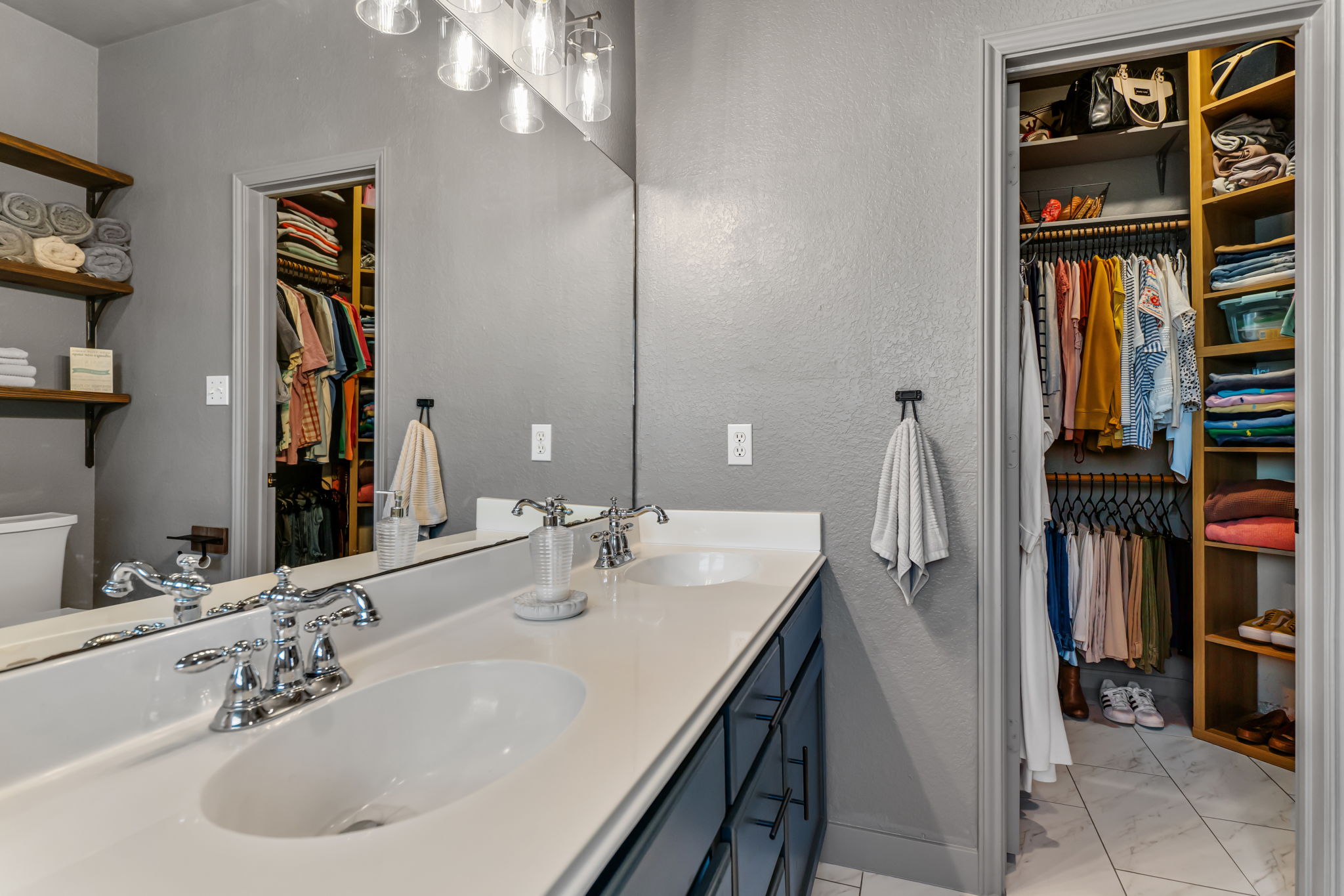 401 Kates Way Hutto, TX 78634 - Photo 18 of 37 Bathroom with a spacious closet, double vanity, a textured wall, and light marble finish flooring