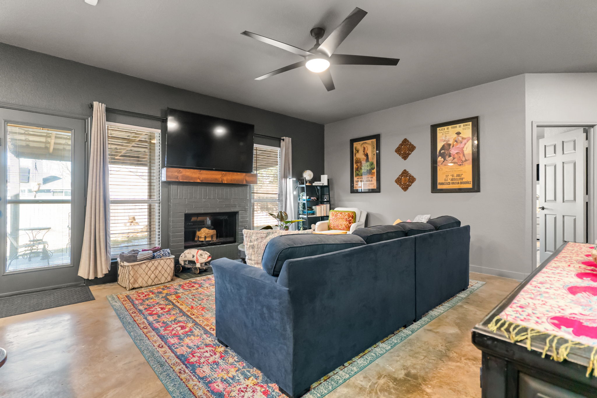 401 Kates Way Hutto, TX 78634 - Photo 6 of 37 Living area with concrete flooring, a fireplace, and a ceiling fan